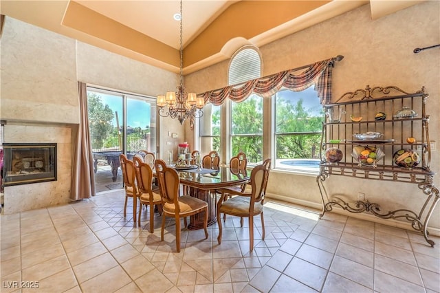 27 Via Paradiso St, Henderson, NV 89011 - dining room featuring lofted ceiling, light tile patterned flooring, a chandelier, and a high end fireplace