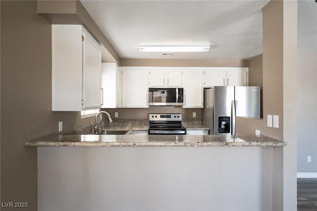 6873 Tamarus St Unit 201, Las Vegas, NV 89119 - kitchen with stainless steel appliances, a peninsula, light stone counters, and a sink