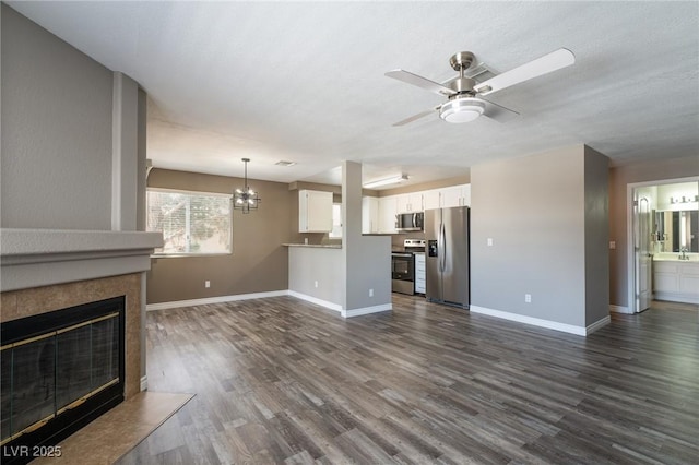 6873 Tamarus St Unit 201, Las Vegas, NV 89119 - unfurnished living room with dark wood-style floors, a ceiling fan, baseboards, and a tiled fireplace