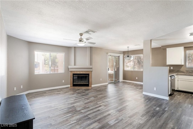 6873 Tamarus St Unit 201, Las Vegas, NV 89119 - unfurnished living room featuring a textured ceiling, plenty of natural light, dark wood-style floors, and baseboards