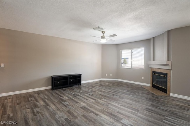 6873 Tamarus St Unit 201, Las Vegas, NV 89119 - unfurnished living room with a ceiling fan, wood finished floors, a textured ceiling, a tile fireplace, and baseboards
