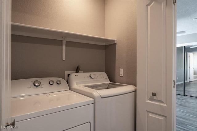 6873 Tamarus St Unit 201, Las Vegas, NV 89119 - laundry area featuring independent washer and dryer, wood finished floors, and a textured wall