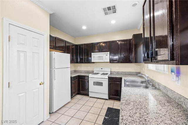 5456 Raccoon Valley Ln, Las Vegas, NV 89122 - kitchen featuring white appliances, a sink, light tile patterned floors, dark brown cabinetry, and recessed lighting