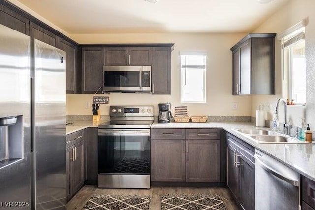2629 Mocha Pearl Ct, North Las Vegas, NV 89086 - kitchen featuring stainless steel appliances, a sink, dark wood-type flooring, dark brown cabinetry, and light countertops