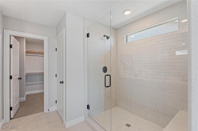 7983 Texas Hills St, Las Vegas, NV 89113 - bathroom featuring a shower stall, a spacious closet, baseboards, and tile patterned flooring