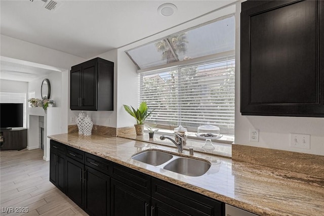 9428 Sierra Summit Ave, Las Vegas, NV 89134 - kitchen with a sink, dark cabinetry, and light stone countertops