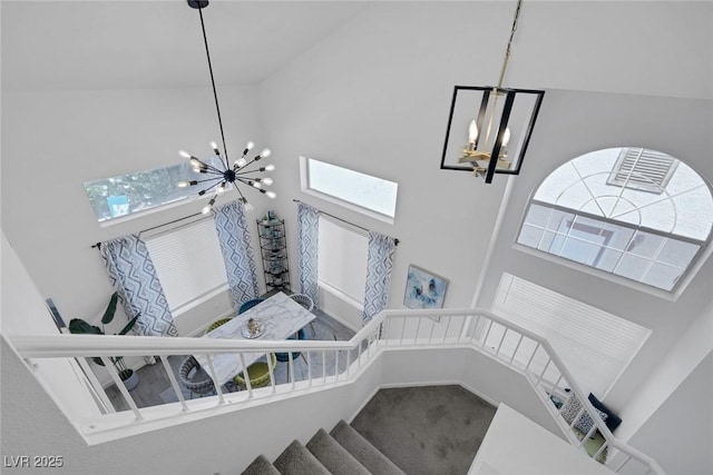 9428 Sierra Summit Ave, Las Vegas, NV 89134 - stairs featuring a chandelier, a high ceiling, plenty of natural light, and carpet flooring