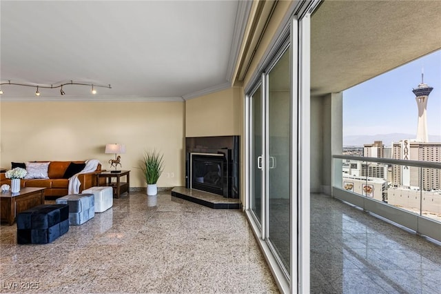 2777 Paradise Rd Unit 2302, Las Vegas, NV 89109 - living room with crown molding, granite floors, a glass covered fireplace, track lighting, and a city view