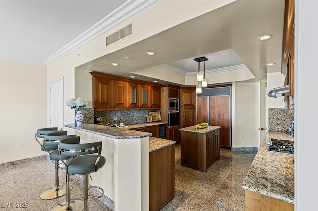 2777 Paradise Rd Unit 2302, Las Vegas, NV 89109 - kitchen featuring built in appliances, crown molding, a center island, light stone countertops, and tasteful backsplash