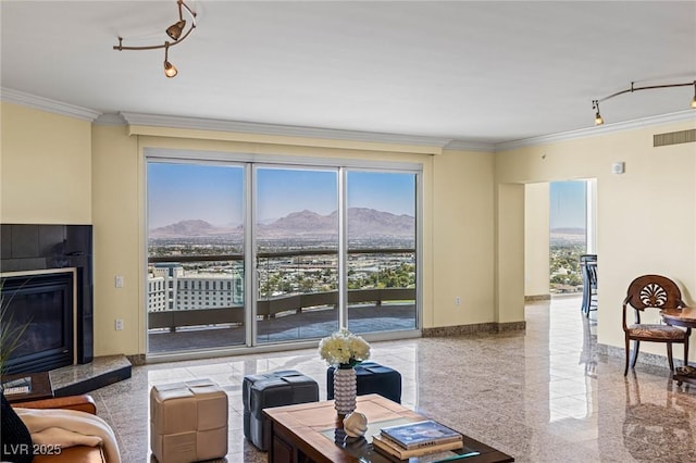 2777 Paradise Rd Unit 2302, Las Vegas, NV 89109 - living room featuring ornamental molding, a mountain view, granite tiled floors, rail lighting, and a tile fireplace