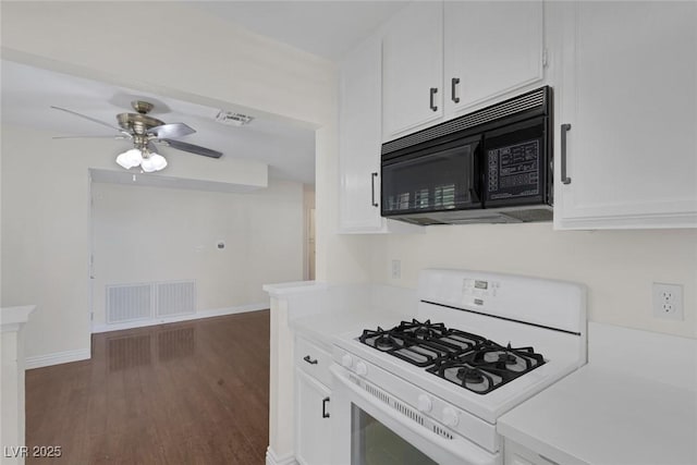 4843 S Torrey Pines Dr Unit 101, Las Vegas, NV 89103 - kitchen with black microwave, white gas stove, white cabinets, light countertops, and wood finished floors
