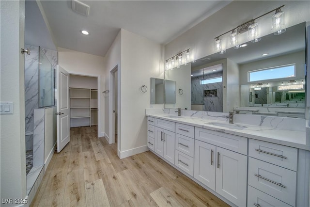 4861 Ridgewood, Pahrump, NV 89061 - full bathroom with a marble finish shower, double vanity, wood finished floors, baseboards, and a walk in closet