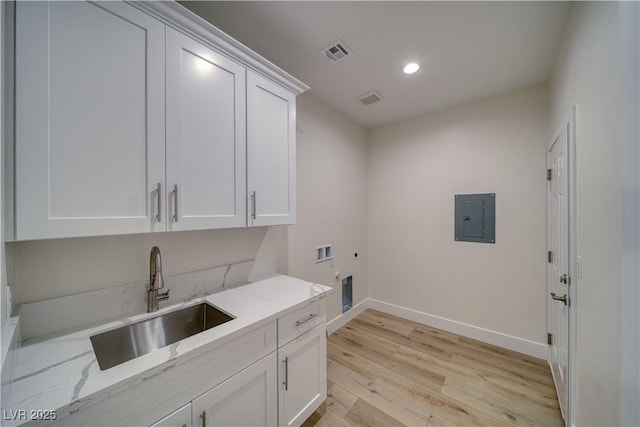 4861 Ridgewood, Pahrump, NV 89061 - laundry area featuring electric panel, baseboards, cabinet space, hookup for an electric dryer, and light wood-style flooring