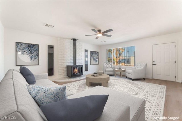 4301 Fortune Ave, Las Vegas, NV 89107 - living area featuring a wood stove, light wood-type flooring, and ceiling fan