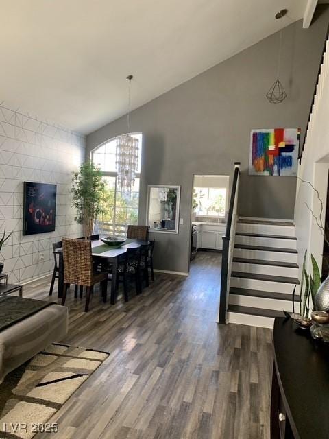 9485 Supernova Ct, Las Vegas, NV 89123 - dining space featuring vaulted ceiling, wood finished floors, plenty of natural light, a chandelier, and stairs