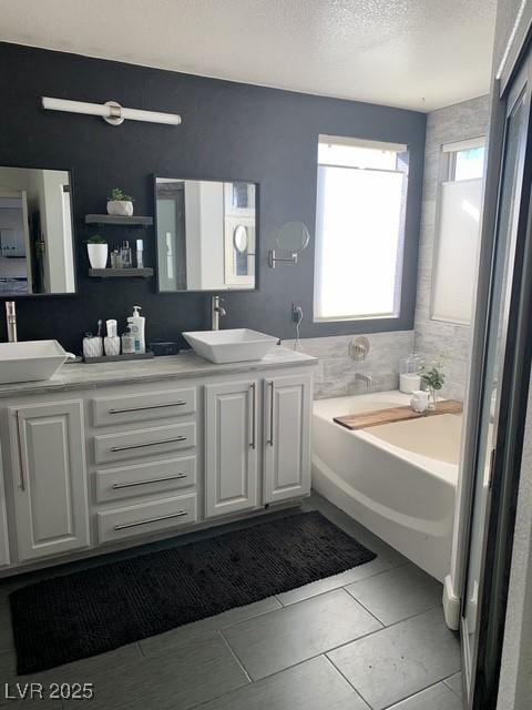 9485 Supernova Ct, Las Vegas, NV 89123 - full bathroom with double vanity, a garden tub, a textured ceiling, and tile patterned flooring