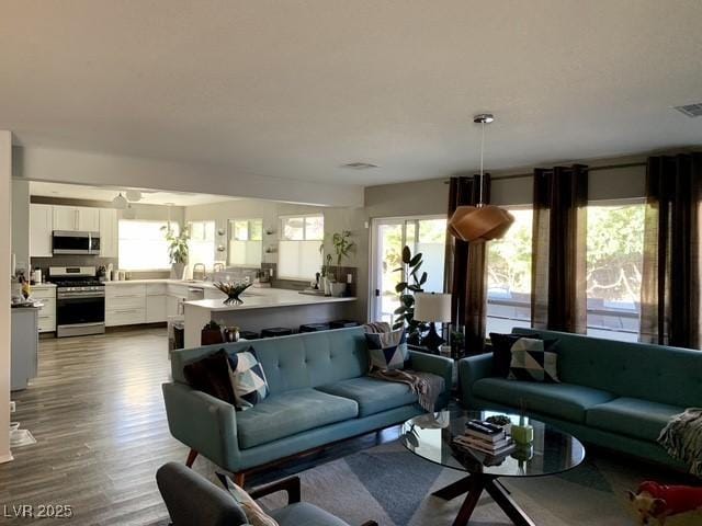 9485 Supernova Ct, Las Vegas, NV 89123 - living room with healthy amount of natural light and dark wood-type flooring