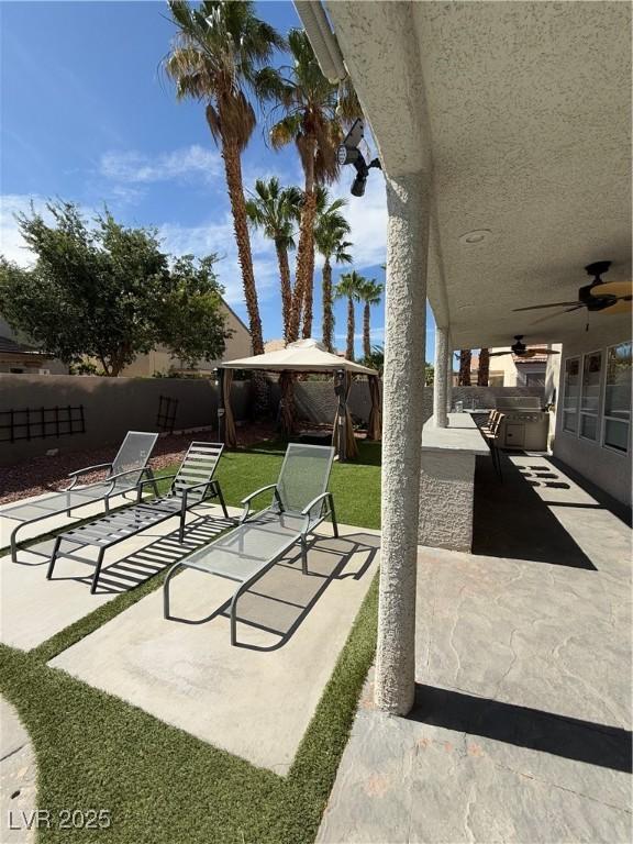 9485 Supernova Ct, Las Vegas, NV 89123 - fenced backyard featuring a gazebo, a ceiling fan, a patio, and exterior kitchen