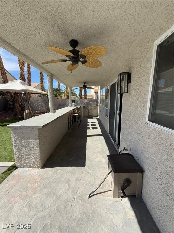 9485 Supernova Ct, Las Vegas, NV 89123 - view of patio with an outdoor kitchen, ceiling fan, and exterior bar