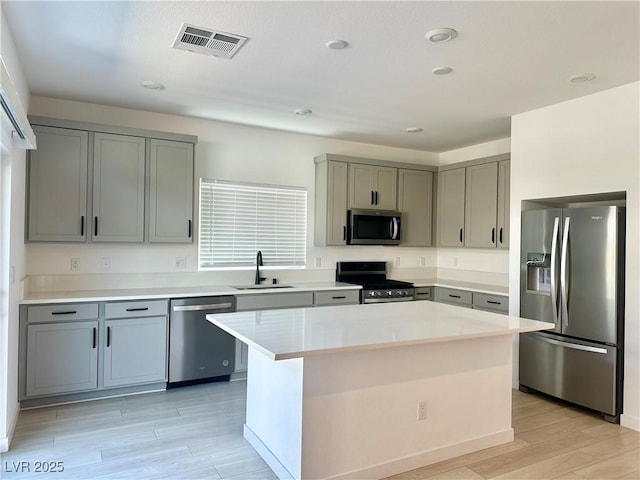 10376 Joaquin Fire St, Las Vegas, NV 89141 - kitchen with appliances with stainless steel finishes, a sink, gray cabinetry, light wood-style floors, and light countertops