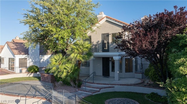 8740 Captains Pl, Las Vegas, NV 89117 - obstructed view of property with stucco siding, a balcony, a fenced front yard, and a gate
