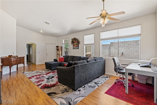 5317 Marietta Ave, Las Vegas, NV 89108 - living room featuring arched walkways, light wood-style flooring, healthy amount of natural light, and a ceiling fan