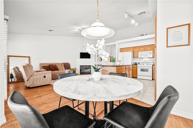 5704 Owl Butte Ct, Las Vegas, NV 89149 - dining area with light wood finished floors and a glass covered fireplace