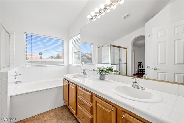 5704 Owl Butte Ct, Las Vegas, NV 89149 - bathroom with double vanity, a garden tub, a shower stall, and tile patterned flooring