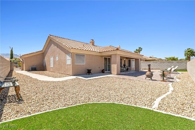 5704 Owl Butte Ct, Las Vegas, NV 89149 - back of property featuring a chimney, stucco siding, a tiled roof, and a fenced backyard