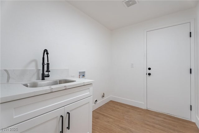 1136 Casady Hollow Ave, Henderson, NV 89012 - laundry room featuring hookup for a washing machine, cabinet space, light wood-style flooring, and baseboards