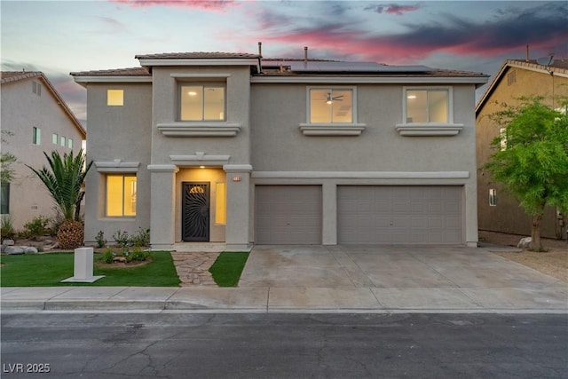1136 Casady Hollow Ave, Henderson, NV 89012 - view of front facade featuring an attached garage, stucco siding, solar panels, and driveway