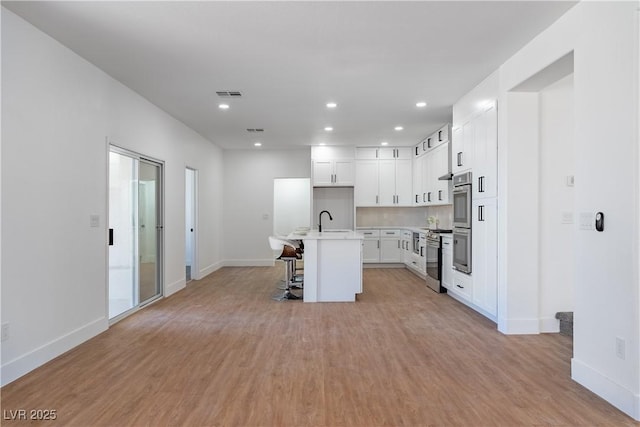 1136 Casady Hollow Ave, Henderson, NV 89012 - kitchen with a sink, baseboards, light wood-style floors, recessed lighting, and double oven
