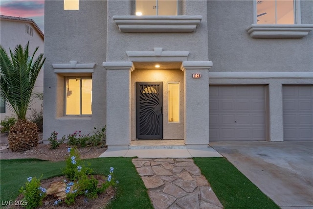 1136 Casady Hollow Ave, Henderson, NV 89012 - exterior entry at dusk with driveway, a garage, and stucco siding