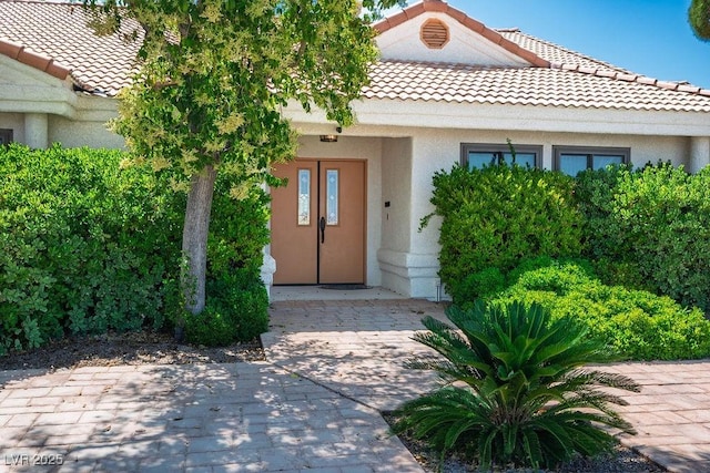 8365 S Hauck St, Las Vegas, NV 89139 - doorway to property featuring a tiled roof and stucco siding