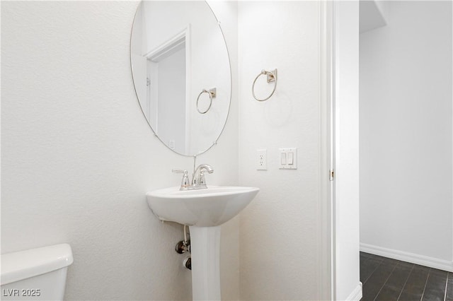 1185 Via Dimartini, Henderson, NV 89052 - half bathroom featuring toilet, baseboards, wood finished floors, and a sink
