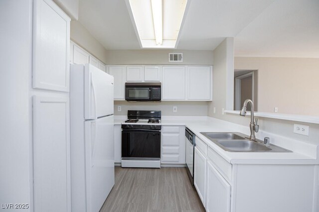 5259 Caspian Springs Dr Unit 203, Las Vegas, NV 89120 - kitchen with gas range oven, black microwave, freestanding refrigerator, a sink, and dishwashing machine