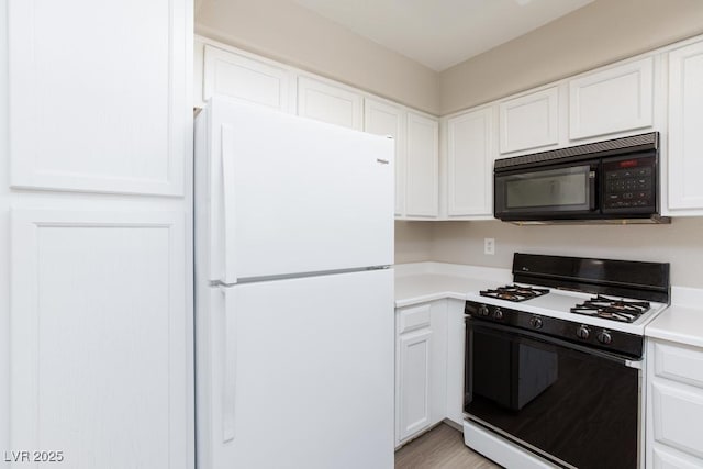 5259 Caspian Springs Dr Unit 203, Las Vegas, NV 89120 - kitchen featuring black microwave, gas range, freestanding refrigerator, white cabinets, and light countertops