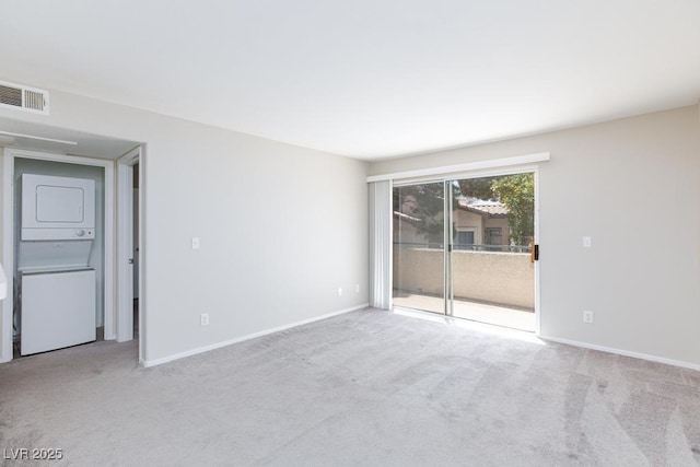 5259 Caspian Springs Dr Unit 203, Las Vegas, NV 89120 - carpeted empty room with stacked washer and clothes dryer and baseboards