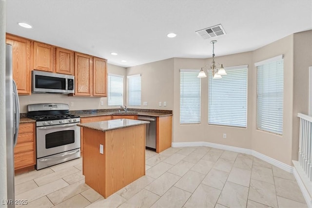 2864 Kinknockie Way, Henderson, NV 89044 - kitchen with appliances with stainless steel finishes, a kitchen island, dark stone counters, recessed lighting, and pendant lighting