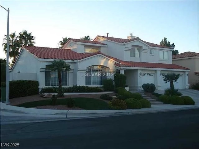 185 Camrose St, Henderson, NV 89074 - mediterranean / spanish-style house featuring stucco siding, a garage, and a tiled roof