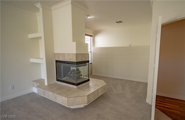 185 Camrose St, Henderson, NV 89074 - unfurnished living room with carpet flooring, a tile fireplace, baseboards, and crown molding