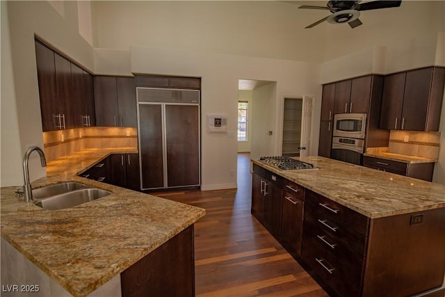 185 Camrose St, Henderson, NV 89074 - kitchen with a sink, built in appliances, ceiling fan, dark wood-type flooring, and light stone counters