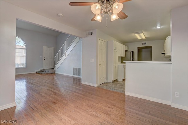 7968 Lisa Dawn Ave, Las Vegas, NV 89147 - unfurnished living room with ceiling fan, light wood-type flooring, baseboards, and stairs