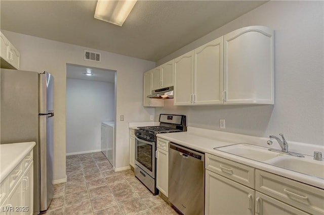 7968 Lisa Dawn Ave, Las Vegas, NV 89147 - kitchen featuring appliances with stainless steel finishes, under cabinet range hood, independent washer and dryer, a sink, and white cabinetry