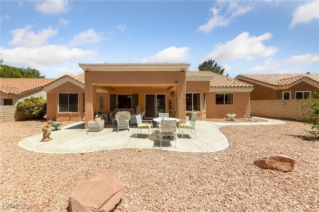2925 Lotus Hill Dr, Las Vegas, NV 89134 - back of property with a fenced backyard, a patio, stucco siding, and a tile roof