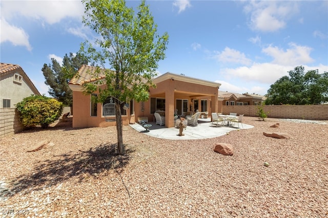 2925 Lotus Hill Dr, Las Vegas, NV 89134 - rear view of house featuring stucco siding, a fenced backyard, a tile roof, and a patio area