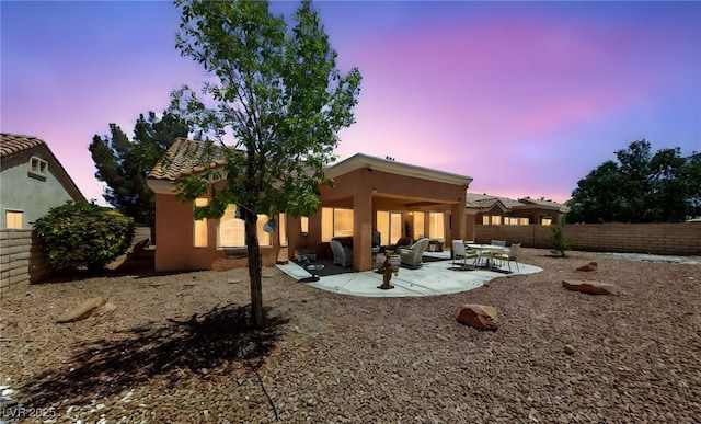 2925 Lotus Hill Dr, Las Vegas, NV 89134 - rear view of house featuring stucco siding, a patio, a fenced backyard, a tiled roof, and an outdoor hangout area