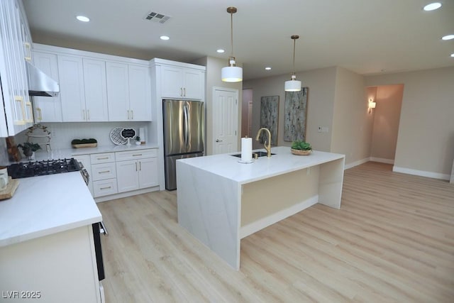 2623 Red Planet St, Henderson, NV 89044 - kitchen featuring freestanding refrigerator, light wood-type flooring, under cabinet range hood, gas range, and baseboards
