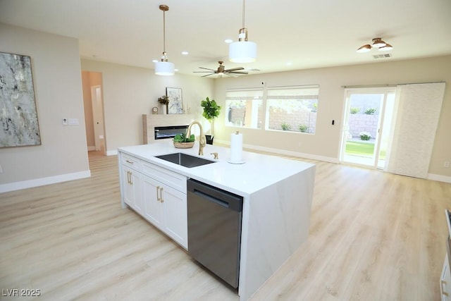 2623 Red Planet St, Henderson, NV 89044 - kitchen featuring dishwashing machine, a sink, a glass covered fireplace, open floor plan, and light wood-type flooring