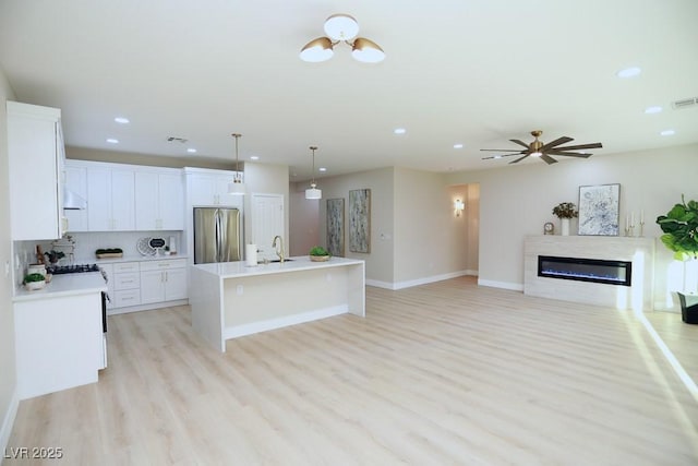 2623 Red Planet St, Henderson, NV 89044 - kitchen featuring stainless steel refrigerator, light wood-style floors, open floor plan, recessed lighting, and light countertops